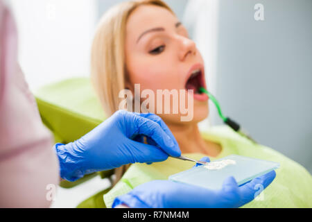 Junge Frau beim Zahnarzt. Zahnarzt besteht in der Reparatur der Zähne. Stockfoto