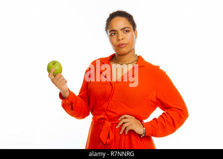 Ernsthafte afro-amerikanische Frau, die das Essen von frischem Obst Stockfoto