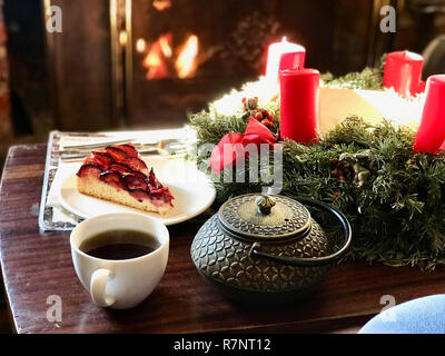 Weihnachten Dekoration vor dem Kamin mit Zwetschge Pflaume Torte Kuchen und Kaffee im Winter Stockfoto