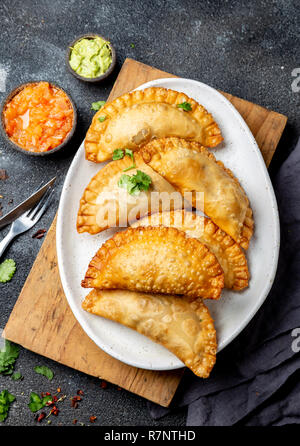 Latin American fried Empanadas mit Tomaten und Avocado Saucen. Ansicht von oben Stockfoto