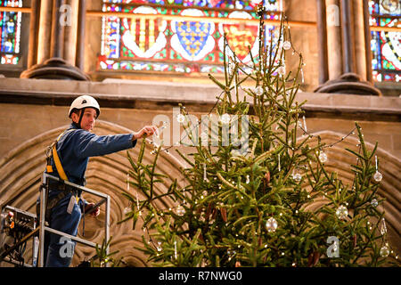 Kirchliche der Kathedrale von Salisbury joiner, Richard Pike schmückt die 34 ft Fichte Weihnachtsbaum, an der Longleat Immobilien gefällt, da die endgültige Garnituren, einschließlich 1000 LED-Leuchten, Glas Kugeln und Eis Tröpfchen, die auf dem Baum, der vor dem Westen Fenster steht platziert sind. Stockfoto