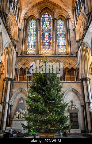 Kirchliche der Kathedrale von Salisbury joiner, Richard Pike schmückt die 34 ft Fichte Weihnachtsbaum, an der Longleat Immobilien gefällt, da die endgültige Garnituren, einschließlich 1000 LED-Leuchten, Glas Kugeln und Eis Tröpfchen, die auf dem Baum, der vor dem Westen Fenster steht platziert sind. Stockfoto