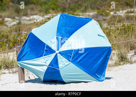 Sanibel Island, USA Bowman's Beach, Florida mit Nahaufnahme des Regenschirms auf Sand, niemand während der sonnigen Tag, weg von Hurricane storm Wind ausgeblasen Stockfoto