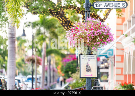 Neapel, USA - 29. April 2018: Bunte Blumentopf hängenden Korb auf der Avenue in Florida downtown Strand Stadt Stadt während der sonnigen Tag, Straße Stockfoto