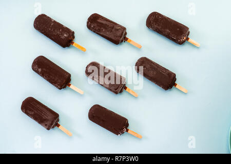Schokolade Eis auf einem hellblauen Hintergrund, Popsicle auf einem Stick Stockfoto