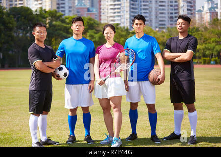 Outdoor Portrait einer Gruppe von jungen asiatischen Sportler mit Fußball Fußball Basketball Tennisschläger. Stockfoto