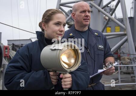 EAST CHINA SEA (30. März 2017) Quartermaster Seaman Rachel Dill, von Elgin, Illinois und der Master Chief Quartermaster James Fox, von Moyock, N.C., verwenden Blinken - Licht Morsesignal an Bord der Amphibisches Schiff USS BONHOMME RICHARD (LHD6) mit Matrosen an Bord der Henry J. Kaiser-Klasse Auffüllung öler USNS Pecos (T-AO 197) während einer Auffüllung auf See zu kommunizieren. Bonhomme Richard, dem Flaggschiff der Bonhomme Richard Expeditionary Strike Group, mit 31 Marine Expeditionary Unit begonnen, ist auf einer Routinepatrouille in der Indo-Asia - Pazifik Region warfighting Readi verbessern Stockfoto