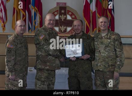 Grafenwöhr, Deutschland - Kapitän Christian Hofman (Mitte rechts), eine US-Armee Experte Bereich Medizinische Abzeichen (EFMB) Empfänger mit dem Deutschen Militär, erhält eine Bescheinigung über den Abschluss von U.S. Army Colonel Brian Almquist (Mitte links), Commander 212th Combat Support Hospital, während einer US-Army Europe EFMB Bewertung in Grafenwöhr, Deutschland am 30. März 2017. Etwa 215 Kandidaten aus der US-Armee und zehn europäischen Partner Nationen nahmen an diesem alle zwei Jahre stattfindenden Bewertung in den Hoffnungen des Erzielens der begehrten US-Armee EFMB aber nur 64 erhalten hat, während der diesjährigen Auswertung. Stockfoto