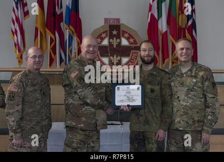 Grafenwöhr, Deutschland - Kapitän Marx Gunnar (Mitte rechts), eine US-Armee Experte Bereich Medizinische Abzeichen (EFMB) Empfänger mit dem Deutschen Militär, erhält eine Bescheinigung über den Abschluss von U.S. Army Colonel Brian Almquist (Mitte links), Commander 212th Combat Support Hospital, während einer US-Army Europe EFMB Bewertung in Grafenwöhr, Deutschland am 30. März 2017. Etwa 215 Kandidaten aus der US-Armee und zehn europäischen Partner Nationen nahmen an diesem alle zwei Jahre stattfindenden Bewertung in den Hoffnungen des Erzielens der begehrten US-Armee EFMB aber nur 64 erhalten hat, während der diesjährigen Auswertung. Stockfoto