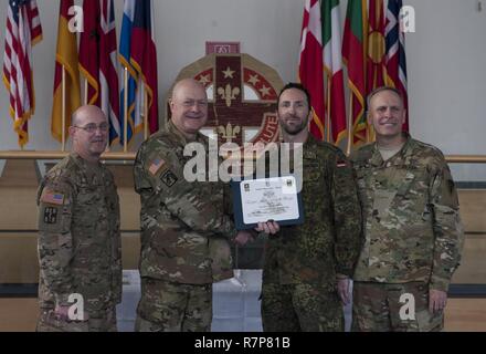 Grafenwöhr, Deutschland - Major Rene Schliebener (Mitte rechts), eine US-Armee Experte Bereich Medizinische Abzeichen (EFMB) Empfänger mit dem Deutschen Militär, erhält eine Bescheinigung über den Abschluss von U.S. Army Colonel Brian Almquist (Mitte links), Commander 212th Combat Support Hospital, während einer US-Army Europe EFMB Bewertung in Grafenwöhr, Deutschland am 30. März 2017. Etwa 215 Kandidaten aus der US-Armee und zehn europäischen Partner Nationen nahmen an diesem alle zwei Jahre stattfindenden Bewertung in den Hoffnungen des Erzielens der begehrten US-Armee EFMB aber nur 64 erhalten hat, während der diesjährigen Auswertung. Stockfoto