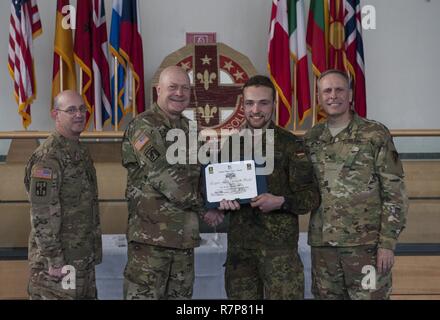 Grafenwöhr, Deutschland - Private First Class Noah Leon Wegmann (Mitte rechts), eine US-Armee Experte Bereich Medizinische Abzeichen (EFMB) Empfänger mit dem Deutschen Militär, erhält eine Bescheinigung über den Abschluss von U.S. Army Colonel Brian Almquist (Mitte links), Commander 212th Combat Support Hospital, während einer US-Army Europe EFMB Bewertung in Grafenwöhr, Deutschland am 30. März 2017. Etwa 215 Kandidaten aus der US-Armee und zehn europäischen Partner Nationen nahmen an diesem alle zwei Jahre stattfindenden Bewertung in den Hoffnungen des Erzielens der begehrten US-Armee EFMB aber nur 64 erhalten hat, während der diesjährigen Auswertung. Stockfoto