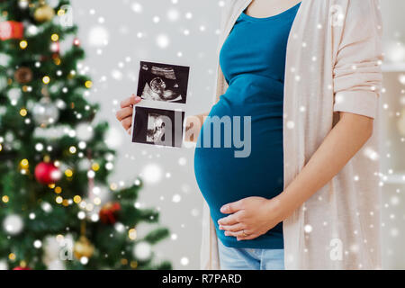 Schwangere Frau mit Ultraschall Bilder zu Weihnachten Stockfoto