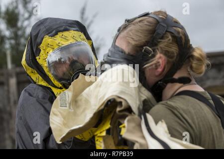 Us Marine Corps Lance Cpl. Heide Mitchell, eine Lageristen mit chemischen biologische, radiologische nuklearen (CBRN) Platoon, G-3, 1 Marine Flugzeugflügel (MAW), Marine Flügel Hauptsitz Squadron 1, entfernt ein Panorama Nova mit Umluftunabhängiges Atemschutzgerät während eines simulierten CBRN-antwort Bohren im Kampf Stadt, Okinawa, Japan, 21. März 2016. Notfallübungen ermöglichen CBRN-Platoon Fähigkeiten der Commander der Ausübung die Funktionsfähigkeit und Effizienz der Folgenbewältigung innerhalb der 1 MAW CBRN-response element Set zu verbessern. Stockfoto