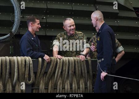 EAST CHINA SEA (21. März 2017) Generalleutnant Lawrence D. Nicholson (Mitte), Kommandierender General des III Marine Expeditionary Force, spricht mit Kapitän Nathan Moyer (rechts), kommandierender Offizier der amphibious Transport dock Schiff USS Green Bay LPD (20) und Kapitän Thomas Shultz, Executive Officer des Schiffes, während einer Tour durch die gut Deck. Green Bay, Teil der Bonhomme Richard Expeditionary Strike Group, mit 31 Marine Expeditionary Unit begonnen, ist auf einer Routinepatrouille in der Indo-Asia - Pazifik Region warfighting Bereitschaft und Haltung als eine fertige Antwort zu verbessern Stockfoto