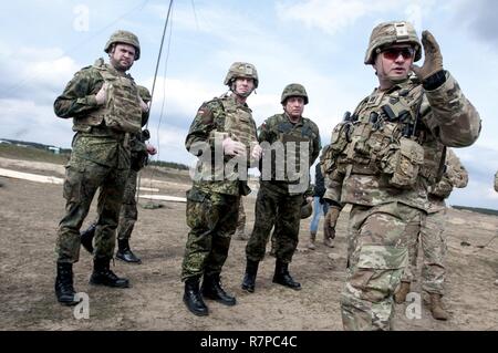 Kapitän Matthew McCoy, Kommandeur der Alpha Company, 1st Battalion, 179Th Infantry Regiment, 45th Infantry Brigade Combat Team, Oklahoma Army National Guard und ein Bewohner von Oklahoma City, Schriftsatz Deutsche Brig. Gen. Kai Rohrschneider, Stabschef der US-Armee in Europa (zweiter von links) und polnischer Generalmajor Jan Śliwka (Zweiter von rechts), wie ukrainische Soldaten eine defensive Position während der Live-Fire Training am Yavoriv Combat Training Center des internationalen Friedens und der Sicherheit, in der Nähe der Yavoriv, der Ukraine, der am 21. März geplant haben. Stockfoto