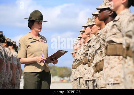 Us Marine Corps Gunnery Sgt. Tifanni Hebron, Drill Master, 4.BATAILLON, rekrutieren Training Regiment, (links) wertet eine mit Platoon 4010, 4.BATAILLON, rekrutieren Training Regiment während eines abschließenden Bohrer Bewertung auf Peatross parade Deck auf Marine Corps Depot rekrutieren, Parris Island, S.C., 22. März 2017 einzustellen. Die rekruten werden für die Bohrmaschine zählte nach Vertrauen, Liebe zum Detail und Disziplin. Stockfoto