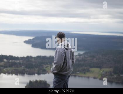 Eiche Hafen Waschen (21. März 2017) US Navy Chaplain Cdr. Marc DiConti, dauert einen Moment die Aussicht von der Spitze des Mt zu genießen. Erie während einer Community Relations Projekt (COMREL) am Mt. Erie Park in Anacortes Gemeinschaft Wald. DiConti zusammen mit 30 Matrosen aus verschiedenen Naval Air Station Whidbey Island (NASWI) Befehle im Park Verschönerung Projekt teilgenommen haben. Die Segler gewandert und hob Abfall entlang der 5 km runde Reise trail auf die Spitze des Mt. Erie als militärische Botschafter in Washington Trails Association. Stockfoto