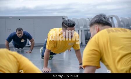 Philippinischen MEER (23. März 2017) Kulinarische Specialist 1. Klasse Rodolfo Elston ruft Push-ups zu Chief Petty Offiziere und Unteroffiziere der ersten Klasse während Chief Petty Officer (CPO) 365 körperliches Training an Bord des amphibious Transport dock Schiff USS Green Bay LPD (20). Green Bay, Teil der Bonhomme Richard Expeditionary Strike Group, mit 31 Marine Expeditionary Unit begonnen, ist auf einer Routinepatrouille in der Indo-Asia-pazifischen Region Partnerschaften zu verbessern und eine fertige Antwort für jede Art von Kontingenz. Stockfoto