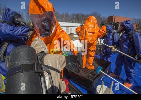 Strike Team Mitglieder Sgt. Joe Bercovic, zweiter von links, und die Mitarbeiter der Sgt. Nicky Lam, Center, beide mit 21 Waffen der New Jersey National Guard von Mass Destruction-Civil Support Team, werden durch Picatinny Arsenal Feuerwehrmänner während einer Übung mit dem Picatinny Arsenal Feuerwehr am New Jersey Homeland Defense Homeland Security Center am Picatinny Arsenal, N. J., März 23, 2017 dekontaminiert werden. Das 21 WMD-CST ist eine gemeinsame Einheit aus New Jersey National Guard Soldaten und Piloten, deren Aufgabe es ist, die zivilen Autoritäten durch die Identifizierung von chemischen, biologischen, radiologischen, Stockfoto