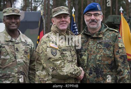 Grafenwöhr, Deutschland - U.S. Army Brigadegeneral Steven Ainsworth (Mitte links), Stellvertretender Kommandierender General des 21 Theater Sustainment Command, schüttelt Hände mit Major General Ulrich Baumgartner (rechts), Kommandierender General der Bundeswehr Operative medizinische Unterstützung Befehl, nach der Unterzeichnung der ersten Einheit Gesellschaftsvertrag der Partnerschaft bei der US-Armee Europa Experten Bereich Medizinische Abzeichen Bewertung in Grafenwöhr, Deutschland am 24. März 2017. Etwa 215 Kandidaten aus der US-Armee und zehn europäischen Partner Nationen nahmen an diesem alle zwei Jahre stattfindenden Bewertung in den Hoffnungen des Erzielens der begehrten Stockfoto