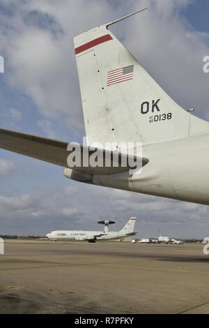 Die statische Schwanz eines E-3G Airborne Warnung und Steuerung von Flugzeugen im Vordergrund Frames einer anderen E-3, wie es mit dem Taxi in Richtung der Start- und Landebahn für eine Mission mit der 552Nd Air Control Wing März 24, 2017, Tinker Air Force Base, Oklahoma. Die E-3 AWACS feierte sein 40-jähriges Jubiläum bei Tinker AFB am 23. März 2017. Stockfoto