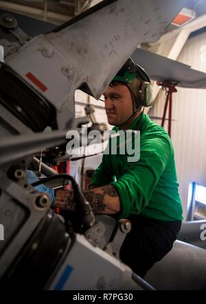 Pazifik (20. März 2017) Aviation Elektriker Mate 2. Klasse Matt Bouley, zu Hubschrauber Maritime Strike Squadron (HSM) 75, reinigt den starrantrieb von einem MH-60R Sea Hawk Hubschrauber an Bord der geführte-missile Cruiser USS Princeton (CG59) während der Fahrt für Composite Trainingsgerät Übung (COMPTUEX) mit der nimitz Carrier Strike Group in Vorbereitung für eine bevorstehende Implementierung zugewiesen. COMPTUEX Tests die Mission die Bereitschaft der Aktiven der Streik Gruppe durch simulierte Szenarien und ihre Fähigkeit als integrierte Einheit durchzuführen. Stockfoto