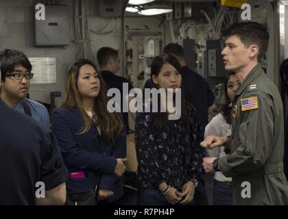 SASEBO, Japan (25. März 2017) Lieutenant Reed Smith, ein hangardeck Offizier an Bord der Amphibisches Schiff USS BONHOMME RICHARD (LHD 6), gibt der Okinawanischen Studenten eine Tour des Chaos Decks an Bord der Amphibisches Schiff USS BONHOMME RICHARD (LHD6). Bonhomme Richard, dem Flaggschiff der Bonhomme Richard Expeditionary Strike Group, mit Eingeschifft 31 Marine Expeditionary Unit (MEU) ist auf einer Routinepatrouille in der Indo-Asia - Pazifik Region warfighting Bereitschaft und Haltung als ready-Response Force für jede Art der Kontingenz zu verbessern. Stockfoto