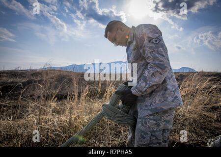 Staff Sgt. Marcanthony Khan, 374 Logistik Bereitschaft Squadron Air Transport Specialist, gewinnt eine Ausrüstung Fallschirm während einer Cargo drop Training März 22, 2017, am Lager Fuji, Japan. Von der Verpackung die Fallschirme zu Ihnen nach der Drop Übungen abgeschlossen sind, werden die 374 LRS ist verantwortlich für jeden Schritt in der Ladung auf die Lieferungen Land sicher, dass auf dem Boden Paletten. Stockfoto