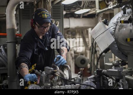 KINBU BAY (27. März 2017) Engineman 3. Klasse Scotty Engelhard, von Lake St. Louis, MO., arbeitet an einem schmieröl Luftreiniger im Maschinenraum an Bord des amphibious Transport dock USS Green Bay LPD (20). Green Bay, Teil der Bonhomme Richard Expeditionary Strike Group, mit 31 Marine Expeditionary Unit begonnen, ist auf einer Routinepatrouille in der Indo-Asia - Pazifik Region warfighting Bereitschaft und Haltung als ready-Response Force für jede Art der Kontingenz zu verbessern. Stockfoto