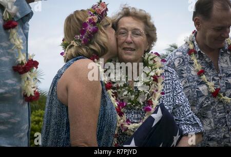 Heather Kaio küsst ihre Mutter Debbie Hazelbaker nach der Trauerfeier für ihren Vater, pensionierter Marine Col. Vincil W. Hazelbaker, an der Hawaiianischen Memorial Park Friedhof am 24. März 2017. Nach der Zeremonie, Hubschrauber von MAG-24 führte eine fehlende Mann Formation, die eine Antenne salute während ein Flypast von Flugzeugen an einer Gedenkfeier durchgeführt, in der Regel in Erinnerung an einen gefallenen Piloten. Hazelbaker war ein Marine Piloten, im Militär für 34 Jahre gedient. Während seines Dienstes, flog er mehr als 680 Einsätze und erwarb die Marine Kreuz für seine außerordentlichen Heldenmut während der vietna Stockfoto