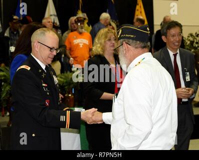 Oberst Damon Gluckern, Leiter des militärischen Unterstützung, Arkansas National Guard, präsentiert Memorial Stifte und schüttelt Hände von Vietnam Veteranen nach dem 2. jährlichen Feiern zum 50. Jahrestag der Vietnam Veteranen Rückkehr aus Krieg am Ft. Wurzeln VA Medical Center in North Little Rock, Arche, am 28. März. Stockfoto