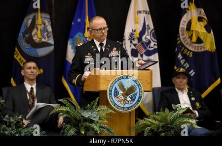 Oberst Damon Gluckern, Leiter des militärischen Unterstützung, Arkansas National Guard, hält die Medaillen von seinem Vater und U.S. Navy Veteran, Petty Officer Larry N. Gluckern, wie er Adressen ein Publikum von Veteranen während des 2. jährlichen 50-Jahr-Feier zur Erinnerung an die Rückkehr von Vietnam Veteranen aus dem Krieg am 28. März, am Ft. Wurzeln VA Medical Center in North Little Rock, Arche. Larry N. Cluck diente in der US Navy von 1966-1970. Gluckern, zwei Kreuzfahrten nach Vietnam an Bord der U.S.S. Konstellation. Er war auch ein Mitglied der Besatzung auf der E-2 ein Hawkeye Radar Ebene. Stockfoto