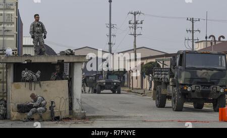 Verteidiger von der 51st Security Forces Squadron vereinbaren in einer defensiven Position kämpfen, während ein Feld Training am Osan Flughafen, der Republik Korea, 23. März 2017. Die übung war ein Teil der 51 SFS Combat Readiness Kurs, der hilft Soldaten Verteidiger aller Ränge verstehen ihre Rolle bei der Unterstützung der Basis und der Beibehaltung der Fähigkeit zu "Kampf heute Abend." Stockfoto