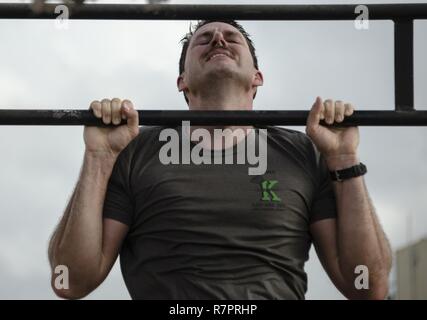 Ein US-Mitglied beteiligt sich an der Pull-up-Teil der Gemeinsamen Krieger Wettbewerb (JWC) auf Lager Lemonnier, Dschibuti, 25. März 2017. Die Teilnehmer des JWC testen sie sich physisch an verschiedenen Veranstaltungen, darunter 20 zeitgesteuerte Pull-ups. Stockfoto