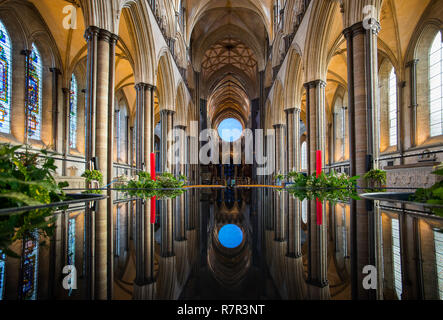 Salisbury, Wiltshire, UK. 11. Dez 2018. Von der Dunkelheit zum Licht im Inneren der Kathedrale von Salisbury, Wiltshire England. "Das Licht" eine Installation von Richard McLester hängt hoch über dem Kirchenschiff und ist hier zu sehen in der Kathedrale Font von William Pye wider. Die 4 Meter Leuchtglobus glüht, von einer Farbe zur anderen fließen für Advent und Weihnachten bis Februar 2019. Credit: Brian Harris/Alamy leben Nachrichten Stockfoto