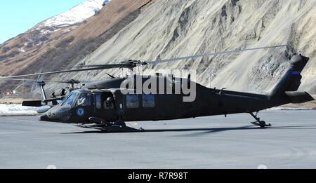 UH-60 Black Hawk Hubschrauber auf das erste Bataillon des Alaska National Guard zugeordnet, 207 Aviation Regiment Taxis auf dem Asphalt auf der Coast Guard Air Station Kodiak am 27. März 2017, wie Sie Verkehr Anbieter und support Personal, um einige der verschiedenen Dörfer auf Kodiak Island, wo Sie die ärztliche Betreuung als Teil der Arktis CARE 2017 medizinische Übung sein. Arktis CARE 2017 ist eine zivil-militärische Zusammenarbeit, die für beide Seiten vorteilhafte Partnerschaften zwischen US-Gemeinschaften und das Verteidigungsministerium zu errichten. Es bietet Ausbildungsmöglichkeiten für US-Militär (Aktiv, Schutz, Stockfoto