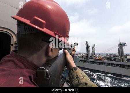 EAST CHINA SEA (30. März 2017) Die Gunner Mate 3. Klasse Trent Burleigh, von Houston, feuert einen Schuß aus dem amphibious Transport dock USS Green Bay LPD (20) auf die militärische Sealift Command flotte Auffüllung öler USNS Pecos (T-AO 197) während einer Auffüllung-auf-See. Green Bay, Teil der Bonhomme Richard Expeditionary Strike Group, mit 31 Marine Expeditionary Unit begonnen, ist auf einer Routinepatrouille in der Indo-Asia - Pazifik Region warfighting Bereitschaft und Haltung als ready-Response Force für jede Art der Kontingenz zu verbessern. Stockfoto