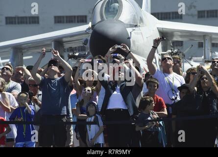 SAN DIEGO (29. März 2017) Zuschauer verfolgen die US Navy Fallschirm Team, den Sprung Frösche, während einer Fallschirmspringen Demonstration über die USS Midway Museum. Der Sprung Frösche sind in San Diego und Antenne Fallschirm Demonstrationen um die Nation zur Unterstützung der Naval Special Warfare und Navy recruiting durchführen. Stockfoto