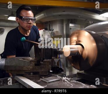 Arabischen Golf (29. März 2017) Maschinen Handwerker 3. Klasse Kody Kratz verwendet eine Drehbank, eine Aluminium Hartmetall drehen Rohr an Bord der Flugzeugträger USS George H.W. zu drehen Bush (CVN 77). Das Schiff ist in den USA der 5. Flotte Bereich für Maßnahmen zur Erhöhung der Sicherheit des Seeverkehrs auf die Verbündeten und Partnern zu beruhigen bereitgestellt, und der Freiheit der Schiffahrt und des freien Handels in der Region erhalten. Stockfoto