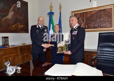 Lt. Gen Vincenzo Coppola (links), Kommandierender General "palidoro "Carabinieri spezialisiert, Brig. Gen. Giovanni Pietro Barbano Kompetenzzentrum für Stabilität Polizeieinheiten (CoESPU) Direktor (rechts), erhält ein Geschenk von Frau Kelly Degnan, Charge d'Affaires ad interim US-Botschaft & Konsulate Italien, während eines Besuchs im Center of Excellence für Stabilität Polizei Units (CoESPU) Vicenza, Italien, März 30, 2017. Stockfoto