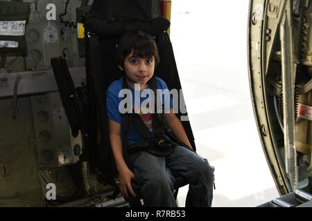 Sohn von ein Gardist bereitgestellte Luft sitzt in der Loadmaster-Sitz von einer c-130, gleichzeitig aber eine starke Anleihen-Event an der North Carolina Air National Guard Base, Charlotte Douglas International Airport, 27. März 2017. Starke Bindungen ist eine Veranstaltung, die Familien der bereitgestellten Flieger, eine Gemeinschaft von Unterstützung schaffen zusammen zu bringen. Stockfoto