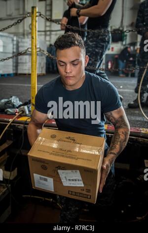 SAN DIEGO (Mar. 30, 2017) Flieger Dante Hernandez lasten Kästen Nahrung auf eine Food Stores Aufzug im Hangar Bucht der Flugzeugträger USS Theodore Roosevelt (CVN 71). Theodore Roosevelt ist derzeit günstig und Naval Air Station North Island homeported. Stockfoto