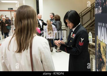 DUBUQUE, IOWA (31. März 2017) Musiker 1. Klasse Kristine Hsia Autogramme ein Programm nach einer Leistung, die von der United States Navy Band an Eleanor Roosevelt Middle School in Dubuqe, Iowa. Die US-Marine Band in neun Mitgliedstaaten während seiner 23-City National Tour, Anschließen der Marine zu Gemeinschaften, die nicht Segler bei der Arbeit regelmäßig sehen. Stockfoto