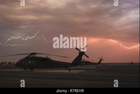Kuwait - Auf dem Camp Buehring Flight Line ein paar UH-60 Black Hawk Hubschraubern aus Florida Army National Guard, Firma A, 1-111 th Aviation Regiment, in Unterstützung der 77th Combat Aviation Brigade eingesetzt, Gesicht ein Gewitter vor der Überschwemmung der Regen beginnt, März 28. Stockfoto