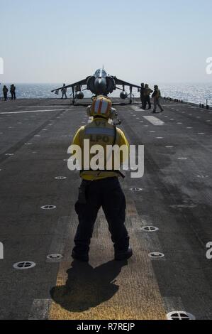 EAST CHINA SEA (3. April 2017) der Luftfahrt Bootsmann Mate (Handling) 1. Klasse Quoc Nguyen, aus San Francisco, leitet ein AV-8B Harrier, zugeordnet zu den 'Kater' der Marine Attack Squadron (VMA) 311, in die Start Position während des Flugbetriebs an Bord der Amphibisches Schiff USS BONHOMME RICHARD (LHD6). Bonhomme Richard, dem Flaggschiff der Bonhomme Richard Expeditionary Strike Group, mit 31 Marine Expeditionary Unit begonnen, ist auf einer Routinepatrouille in der Indo-Asia-pazifischen Region warfighting Bereitschaft und Haltung als ready-Response Force für jede Art der Zusammenarbeit zu verbessern Stockfoto