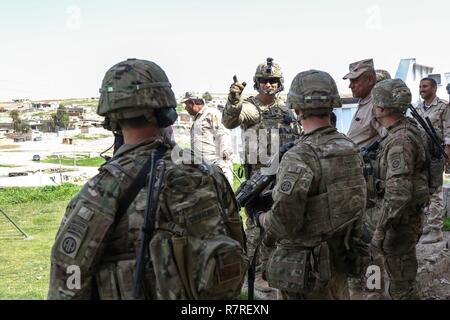 Us-Armee Fallschirmjäger, eingesetzt zur Unterstützung der Combined Joint Task Force - inhärenten lösen und an den 2nd Brigade Combat Team zugewiesen, 82nd Airborne Division, neben 9 irakische Armee Abteilung Mitglieder, Durchführung der Aufklärung für eine neue Patrol Base weiter beraten und Mission in der Nähe von Mossul, Irak, 30. März 2017 zu unterstützen. Die 2 BCT, 82nd Abn. Div., ermöglicht ihre irakischen Sicherheitskräfte Partnern durch das beraten und unterstützen die Mission, die die Planung, Erfassung und Analyse von Intelligenz, Kraft und Präzision Brände die militärische Niederlage der ISIS zu erreichen. CJTF-OIR i Stockfoto