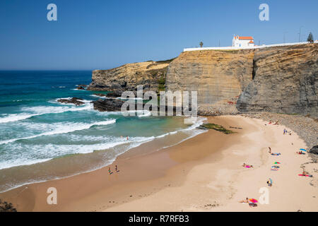 Klippe Kapelle von Igreja de Nossa Senhora do Mar mit Wellen des Atlantiks am Sandstrand in der Morgensonne brechen bei Zambujeira do Mar Stockfoto