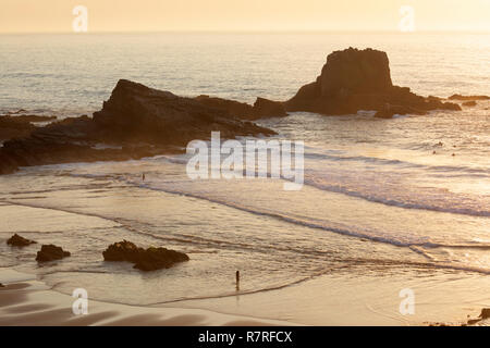 Atlantik Wellen auf den Strand und die Felsen bei Sonnenuntergang brechen, Zambujeira do Mar, Alentejo, Portugal, Europa Stockfoto