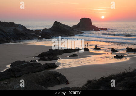 Atlantik Wellen auf den Strand und die Felsen bei Sonnenuntergang brechen, Zambujeira do Mar, Alentejo, Portugal, Europa Stockfoto