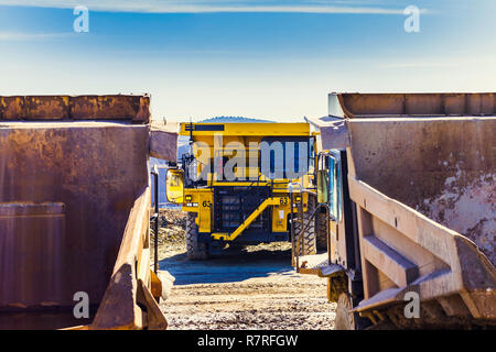 Neue und schwere Lkw in einem Steinbruch Steinbruch für Bergbau, zwischen zwei alten Steinbruch Lkw im Vordergrund. Schwere Geräte Bergbau. Stockfoto